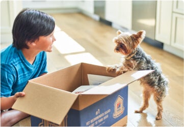 Bambino e cane entusiasti di ricevere i loro prodotti Hill's